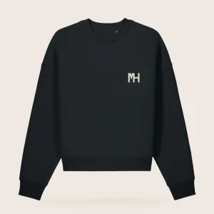 MH Essential Crewneck, black, front view, with a small cream MH monogram at the left chest