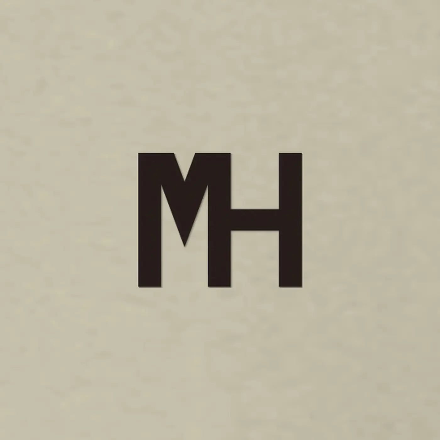 Close-up of a small espresso MH monogram embroidered on the MH Essential Crewneck