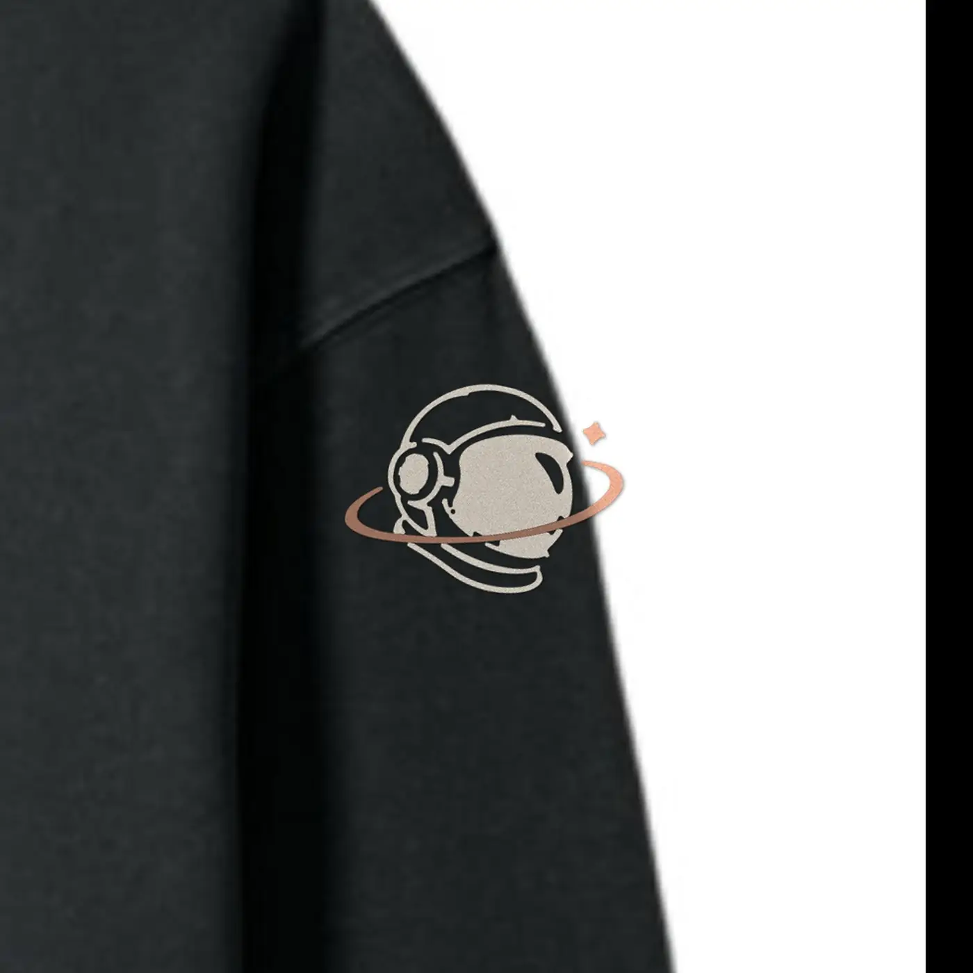 Close-up of the MH astronaut in cream and copper embroidered on the MH Explorer Hoodie