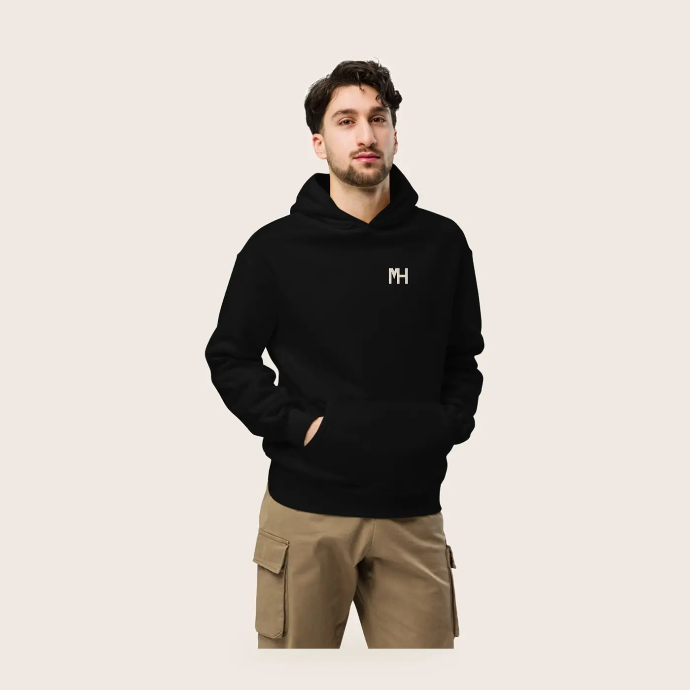 MH Relaxed Hoodie, black, front view, with a small cream MH monogram at the left chest