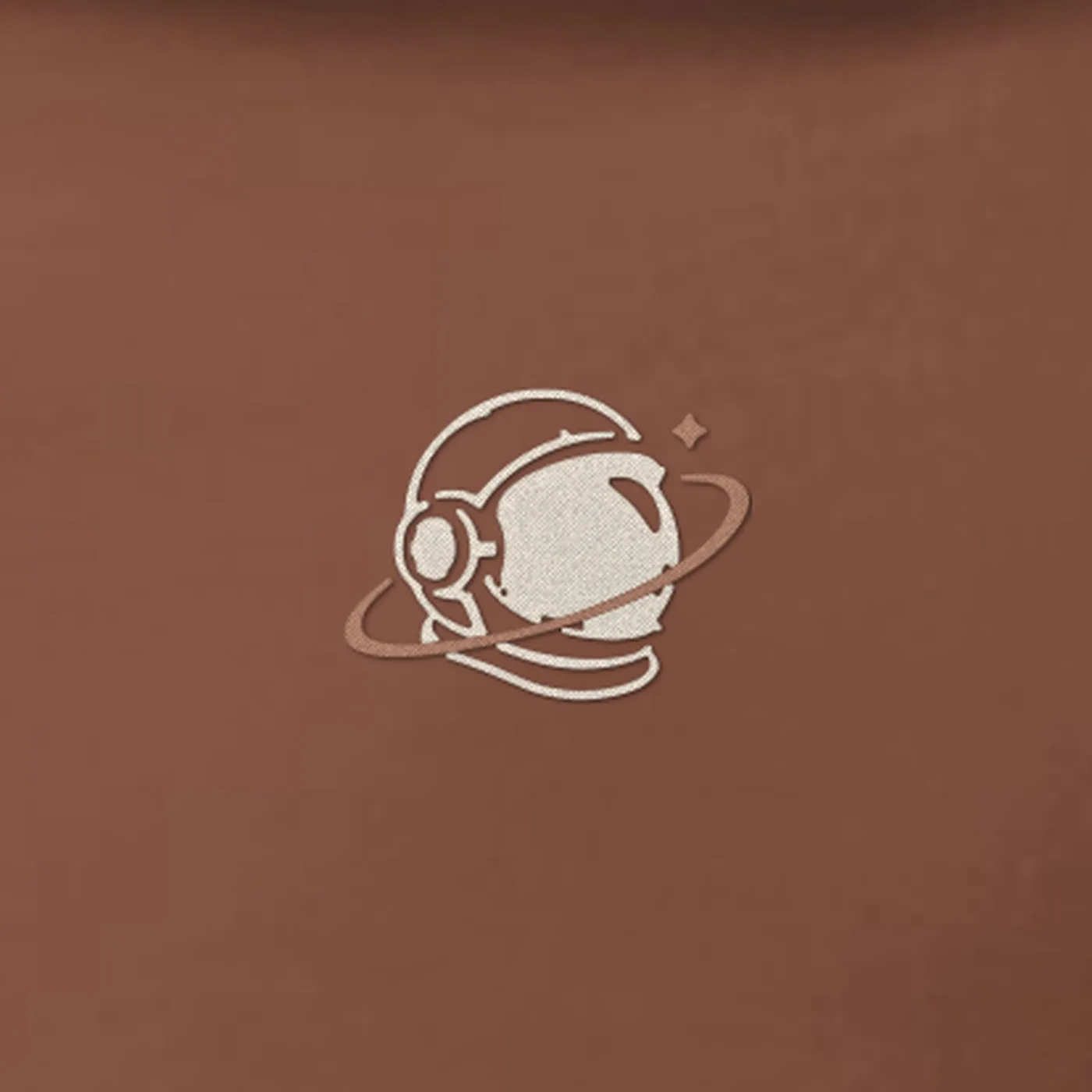 Close-up of the small cream and copper MH astronaut at the centre chest embroidered on the MH Relaxed Astronaut Hoodie